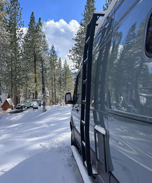 Winnebago Revel with side ladder parked in the snow